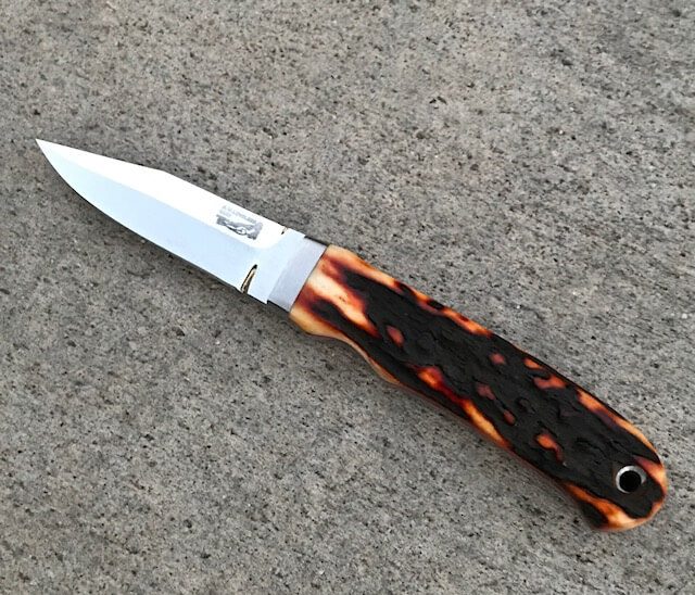 knife with black patterned blade