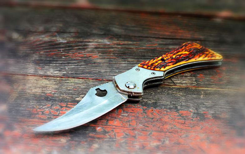 blade sitting on a wooden surface. What your favorite knife is made of concept image.